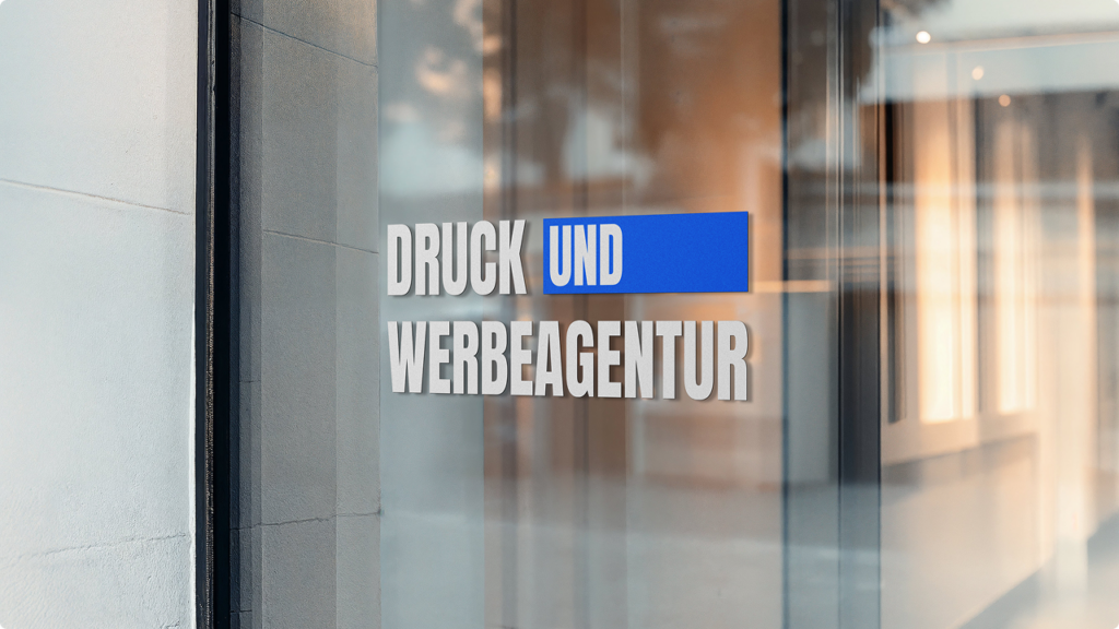 Glass storefront sign reading 'DRUCK UND WERBEAGENTUR' with a blue highlight on 'UND'.